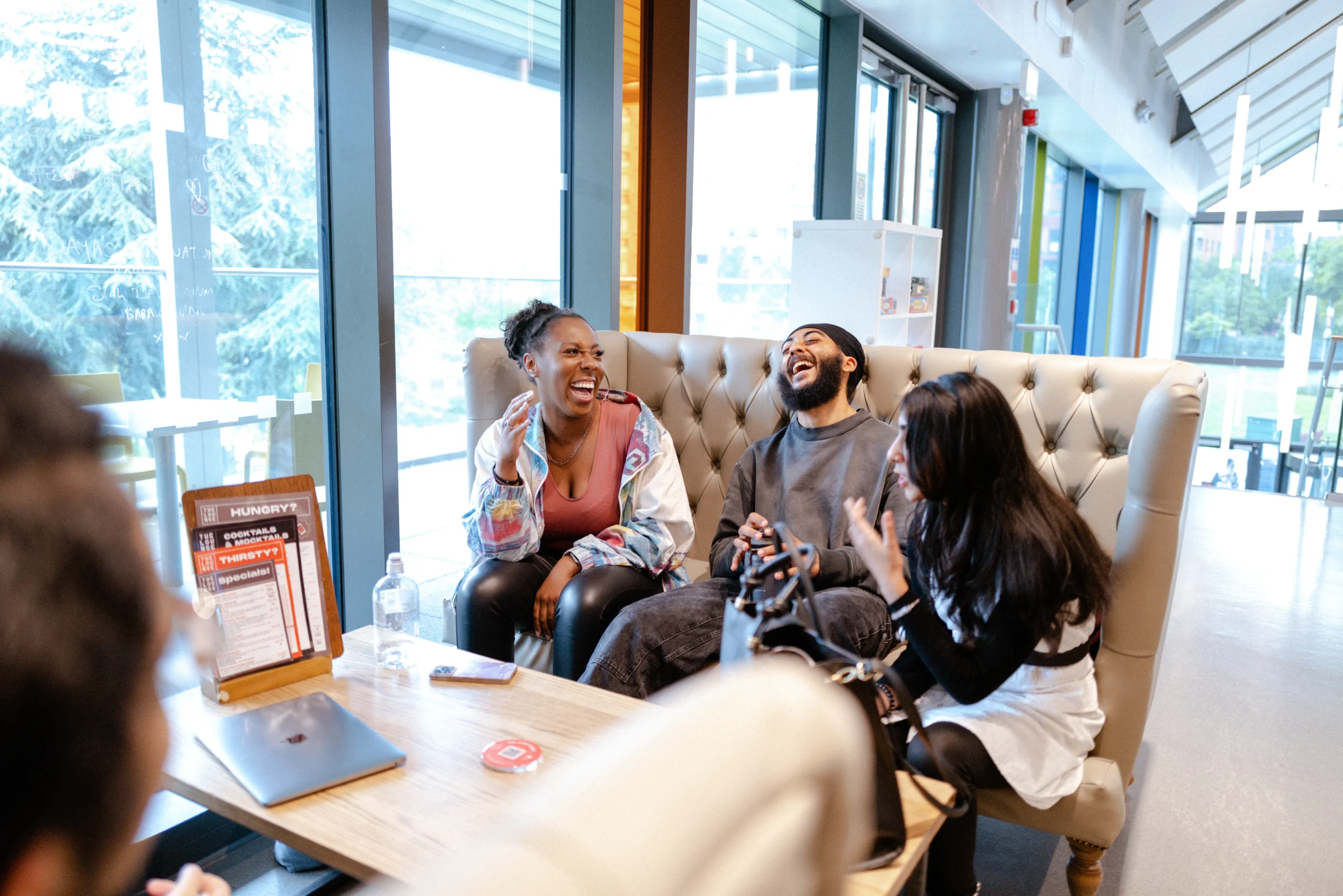Alternative entry routes into undergraduate and postgraduate programmes at Aston University Online - three students laughing together in a cafeteria
