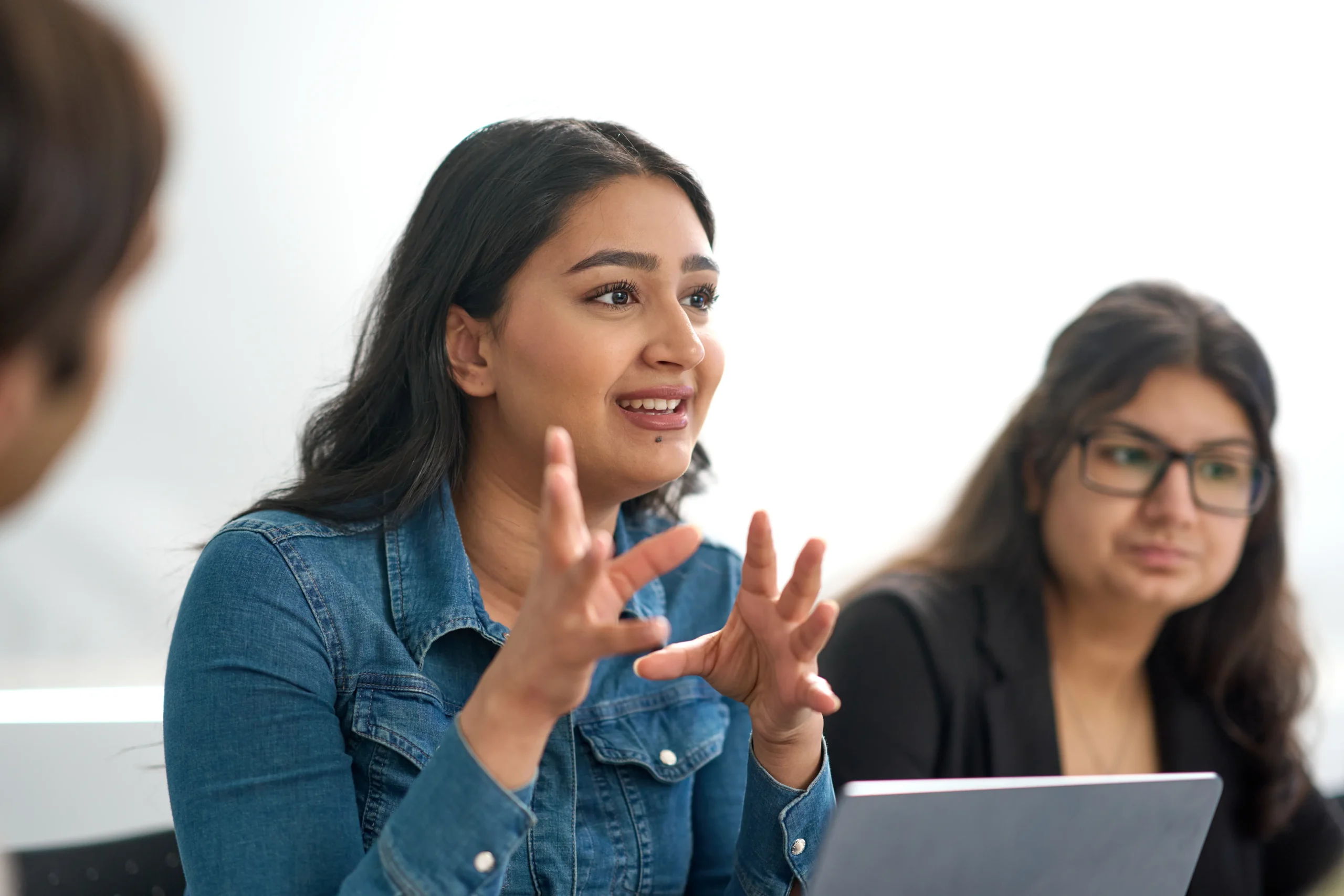 What MBA skills do employers actually hire for - women speaking animatedly to a group at a desk